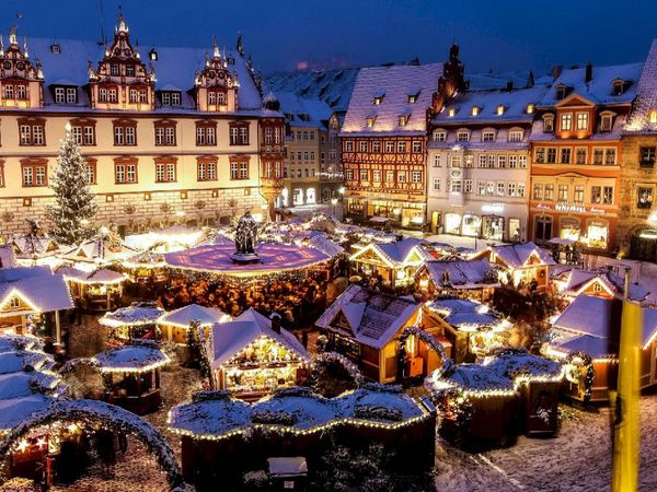 Ansicht des beleuchteten Weihnachtsmarktes Coburg mit historischen Gebäuden im Hintergrund.