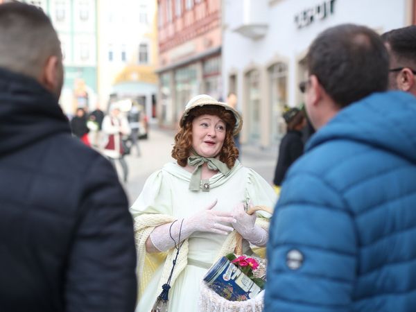 Gäste bei der Kostümführung mit der Zofe Matilde auf dem Coburger Marktplatz.